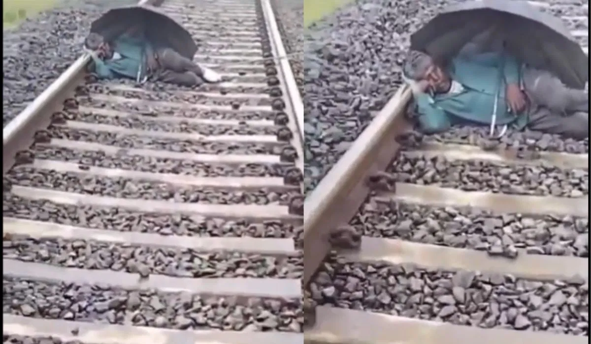 Man with umberalla continues to sleep on railway track